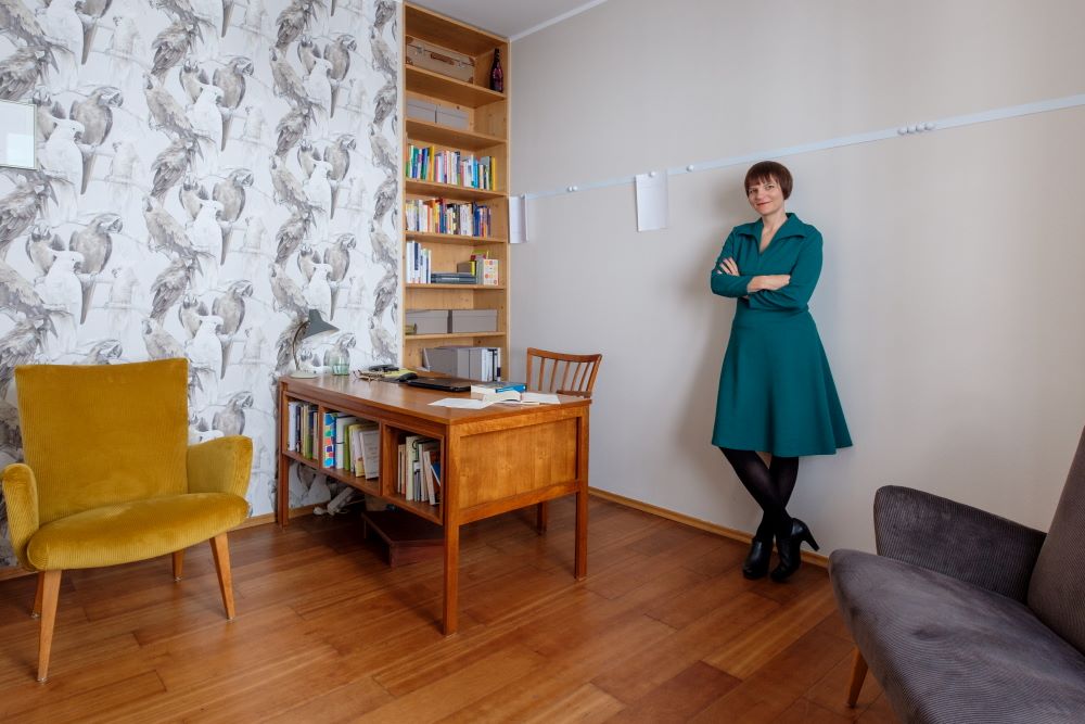 Ein ganz normales kleines Zimmer wird als Büro eingerichtet, im Bild der Nachherzustand: die stolze Inhaberin in ihrem Mid-Century-Büro.