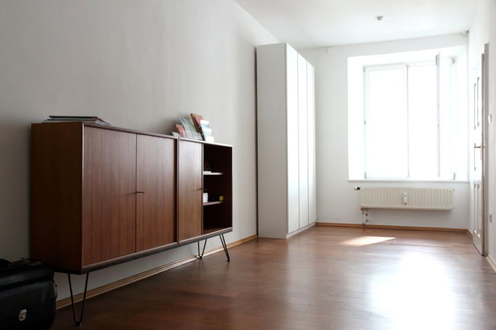 Kleines Zimmer als Büro einrichten mit Charme: eine Mid-Century-Kommode sorgt für genügend Stauraum zur Unterbringung des Werbematerials. Ein großer weißer Ikea-Pax-Schrank bietet Platz für alle weiteren Büromaterialien.