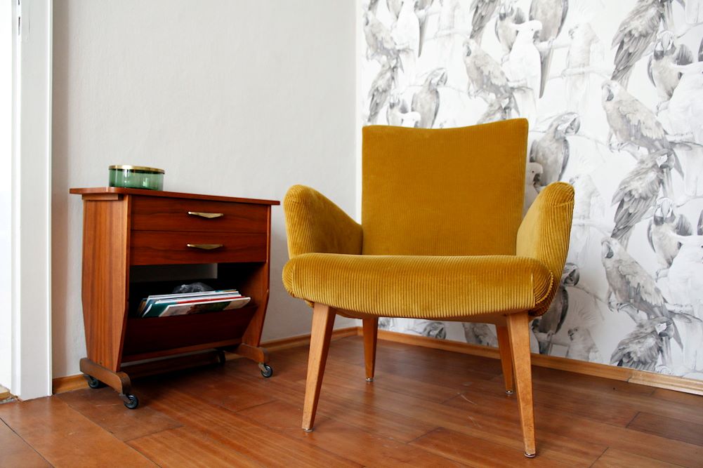 Kleines Zimmer als Büro einrichten und zwar nicht im typischen Business-Look? Beauftragt, getan. Ein senfgelber Sessel aus Cordstoff, ein Teewagen aus Teakholz, beide Mid-Century, sorgen ausreichend für eine büro-untypische Gemütlichkeit.