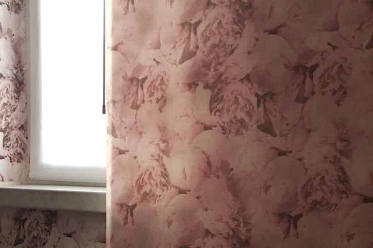 Hier habe ich für meine Kundin ein romantisches Schlafzimmer gestaltet. Zum Beispiel mit einer Schiebegardine bedruckt mit üppigen rosa Pfingstrosen, nebenbei das Muster der Tapete,