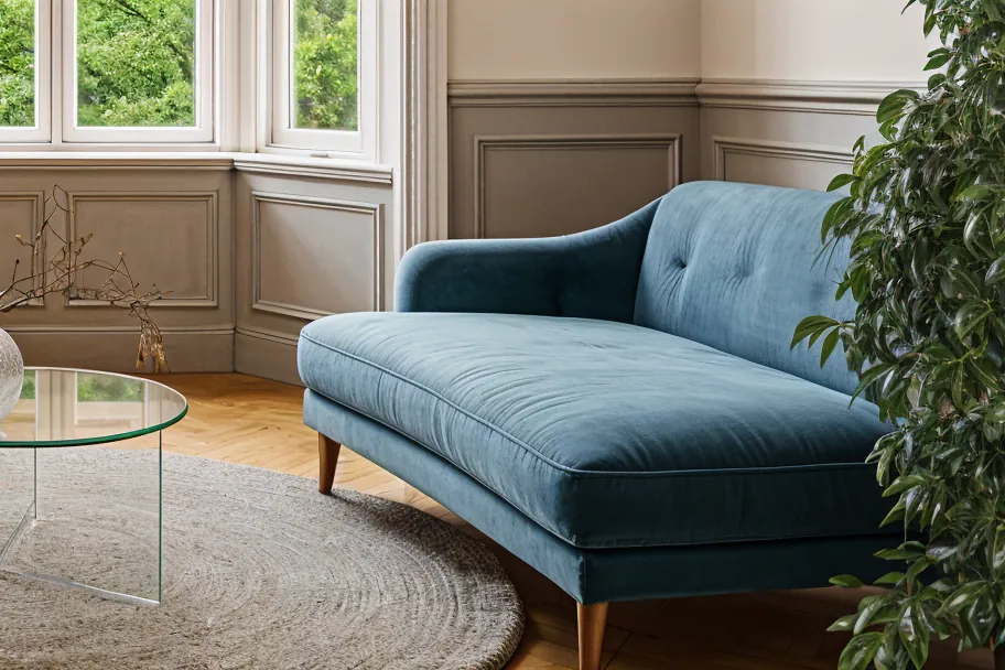 Wohnzimmer mit Erker und Parkett in Leipzig, das Interior Design besteht u. a. aus Glastisch, blauem Sofa und brauem Ledersessel.