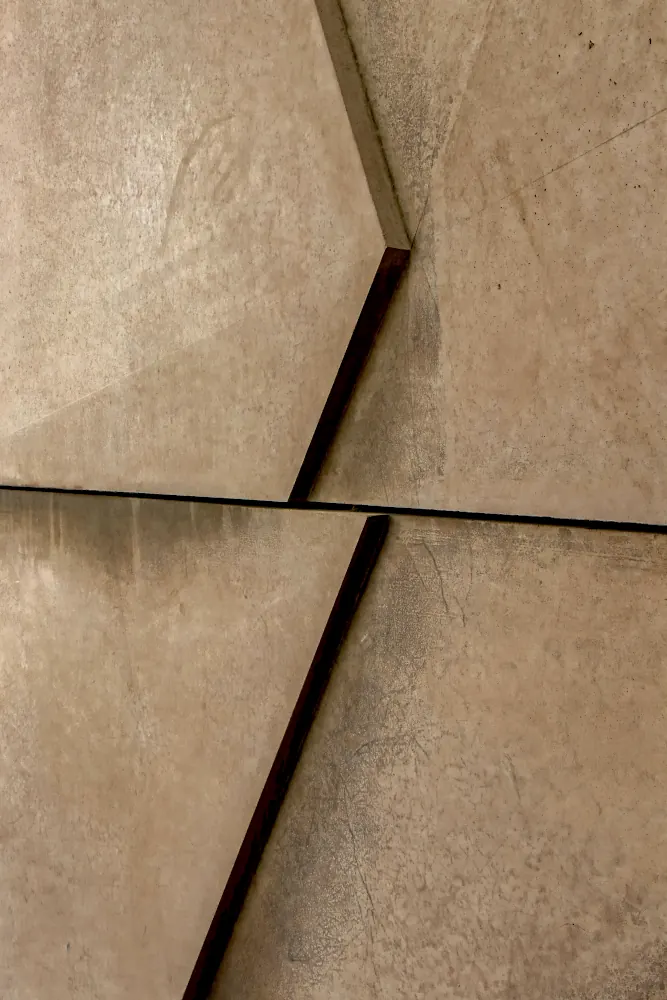 Detailaufnahme einer hochwertigen beigen Wandfliese aus Steinfeinzeug in Betonoptik.